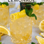 Pinterest Pin with text overlay 'Irish Lemonade', image of whiskey glass filled with ice and Irish lemonade garnished with lemon peel and mint.