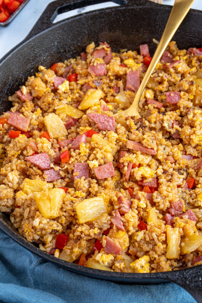 Close up view of Ham fried rice with pineapples and red bell peppers.