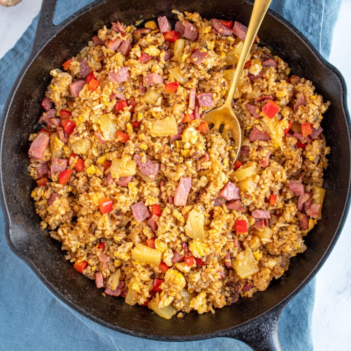 Overhead view of ham fried rice with pineapple and red bell pepper in a skillet.