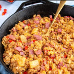 Pinterest pin with text 'Ham Fried Rice with Pineapple', image of black skillet with fried rice and a serving spoon.