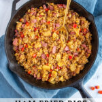 Pinterest pin with text 'Ham Fried Rice with Pineapple', image of black skillet with fried rice and a serving spoon.