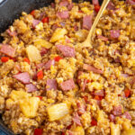 Pinterest pin with text 'Ham Fried Rice with Pineapple', image of black skillet with fried rice and a serving spoon.