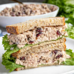 Pinterest Pin with text overlay 'Tuna Salad with Cranberries', image of two halves of a sandwich stacked revealing the no celery tuna salad.