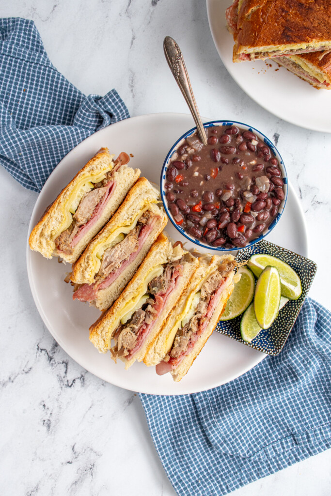 Overhead view of cut open cuban sandwiches revealing the ingredients on the inside.
