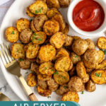 Pinterest Pin with text overlay 'Air Fryer Home Fries', image on baby potato home fries on a plate with a fork.