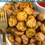 Pinterest Pin with text overlay 'Air Fryer Home Fries', image on baby potato home fries on a plate with a fork.