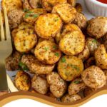 Pinterest Pin with text overlay 'Air Fryer Home Fries', image on baby potato home fries on a plate with a fork.