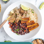 Pinterest Pin with text overlay 'Cuban Bowls', image of a bowl filled with rice, black beans, pork, and fried plantains.