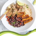 Pinterest Pin with text overlay 'Cuban Bowls', image of a bowl filled with rice, black beans, pork, and fried plantains.