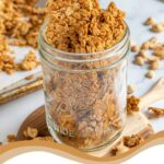 Pinterest Pin with text overlay 'Peanut Butter Granola, image on chunky peanut butter granola in a jar.
