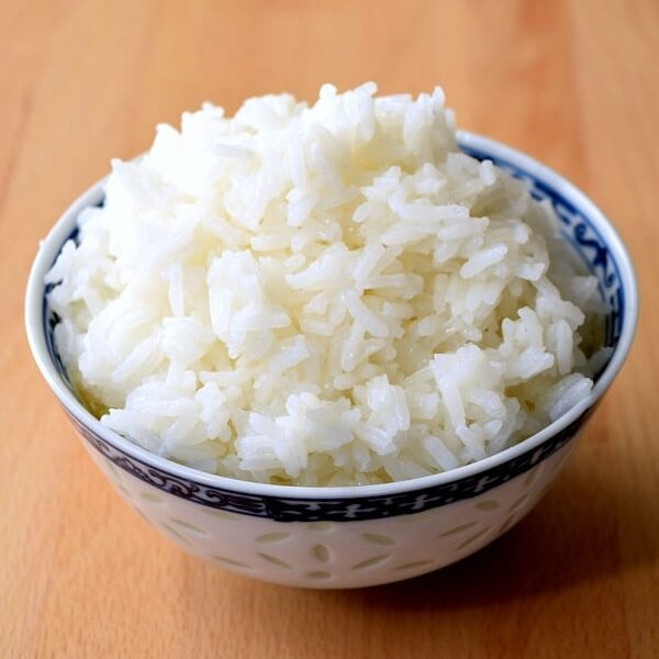 a small bowl of rice on a cutting board