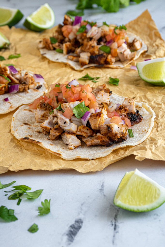 Corn tortillas filled with grilled taco chicken and garnished with pico de Gallo, onions, and cilantro.