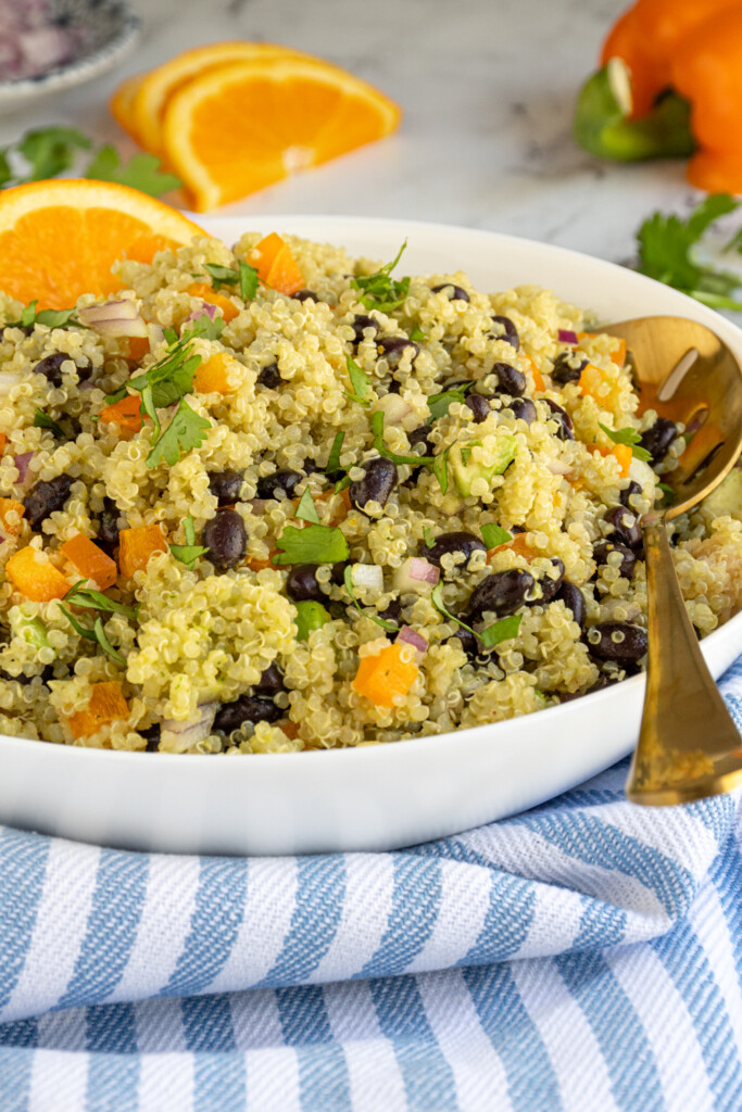 A large white bowl filled with black bean quinoa salad with orange cilantro dressing.