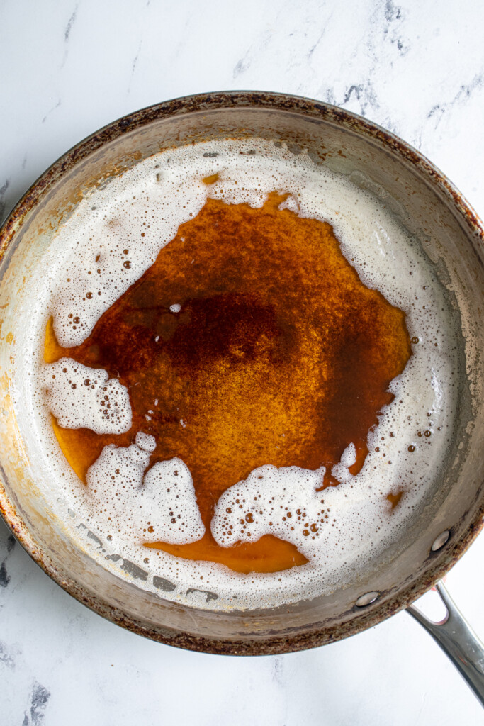 A stainless steel skillet with browned butter.