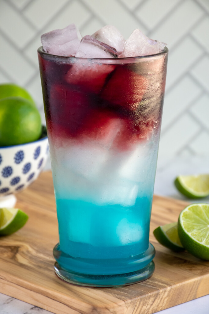 Close up of a red, white, and blue margarita on a cutting board.