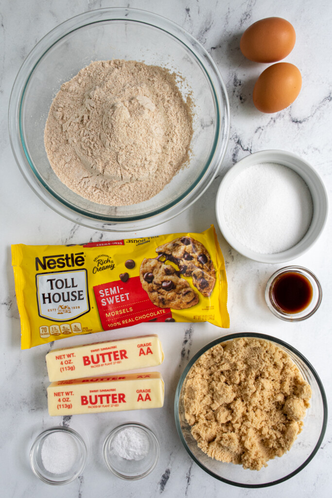 Ingredients needed to make whole wheat chocolate chip cookie bars laid out on a table top.