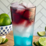 Pinterest pin with text overlay 'red, white, and blue devils margarita', image of a glass with layered red, white, and blue margarita.