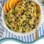 Pinterest Pin with text overlay 'Black bean Quinoa Salad with Orange Cilantro Dressing', image of a white bowl filled with black bean quinoa salad garnish with cilantro.