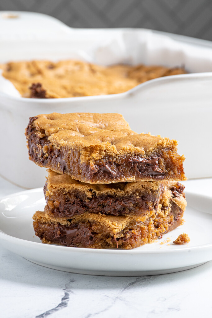 A close up of a stack of whole wheat chocolate chip cookies showing off the insides full of melty chocolate.