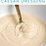 Pinterest pin with text overlay 'Greek Yogurt Caesar Dressing', image of Greek Yogurt Caesar Dressing in a white bowl with a spoon.