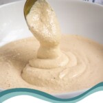Pinterest pin with text overlay 'Greek Yogurt Caesar Dressing', image of Greek Yogurt Caesar Dressing in a white bowl with a spoon.