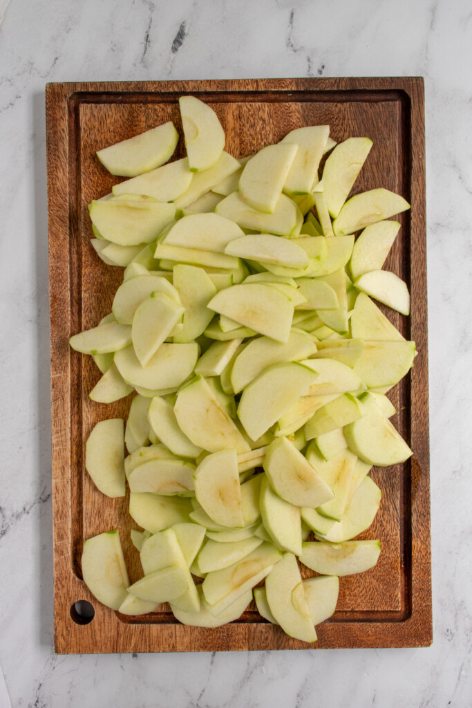 Apple slice on top of a cutting board ready to go into a pie.