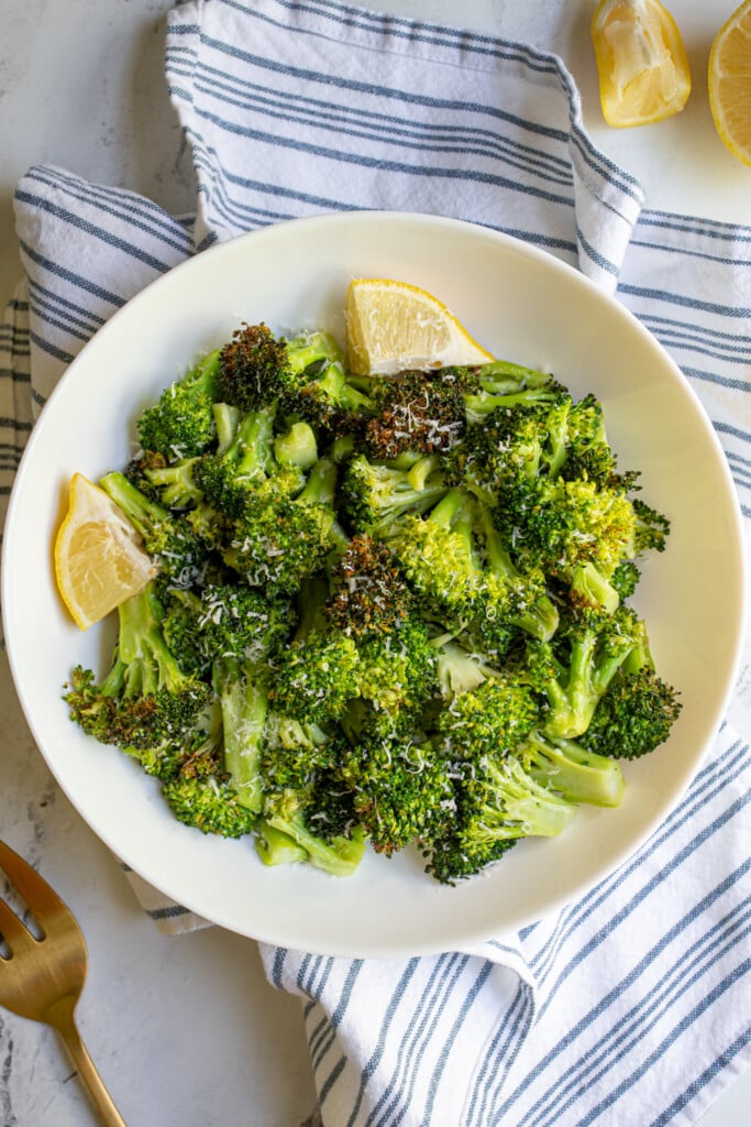 Overhead view of air fryer broccoli in a white bowl.