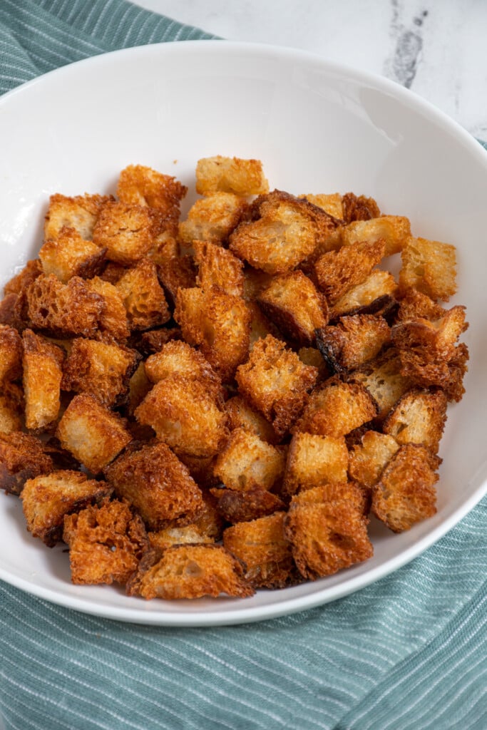 A white bowl crunchy Air Fryer Croutons.