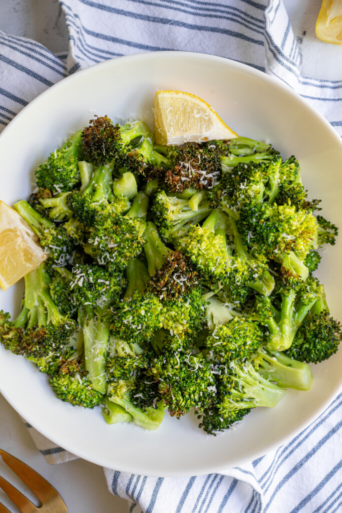 Close up of air fryer broccoli in a bowl garnished with parmesan cheese.