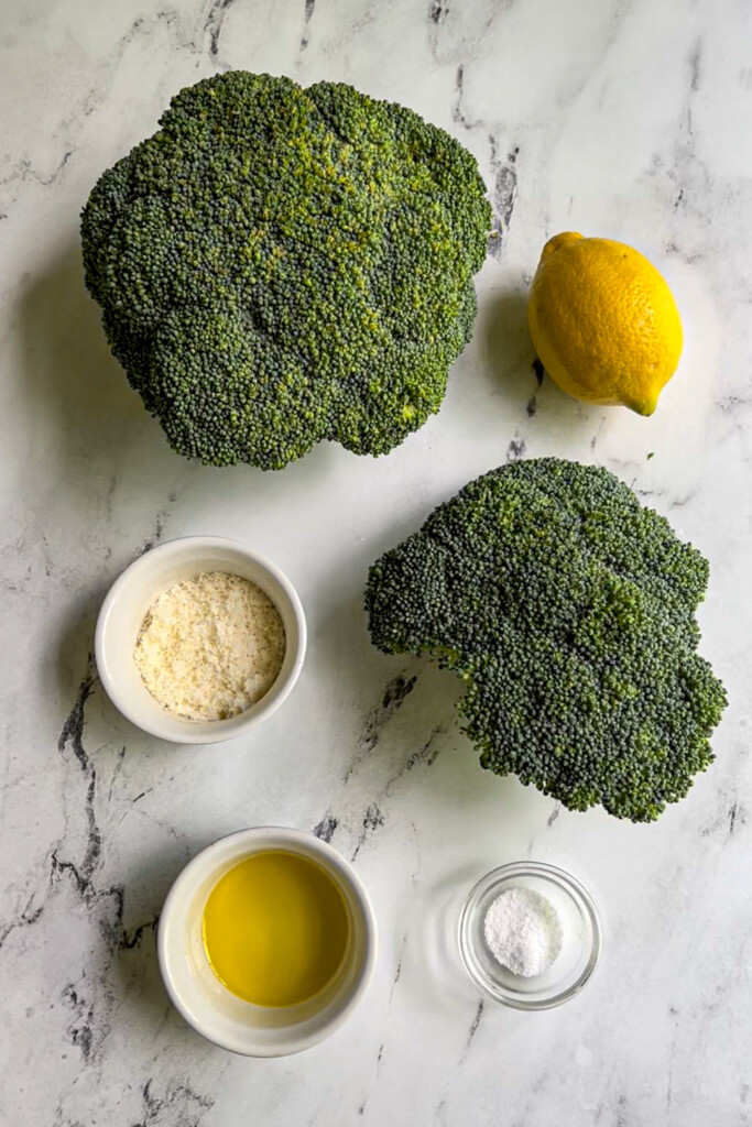 Ingredients needed to make air fryer broccoli laid out on a table top.