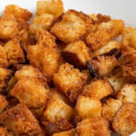 Pinterest pin with text overlay 'Air Fryer Croutons', image of golden brown crunchy croutons in a bowl.