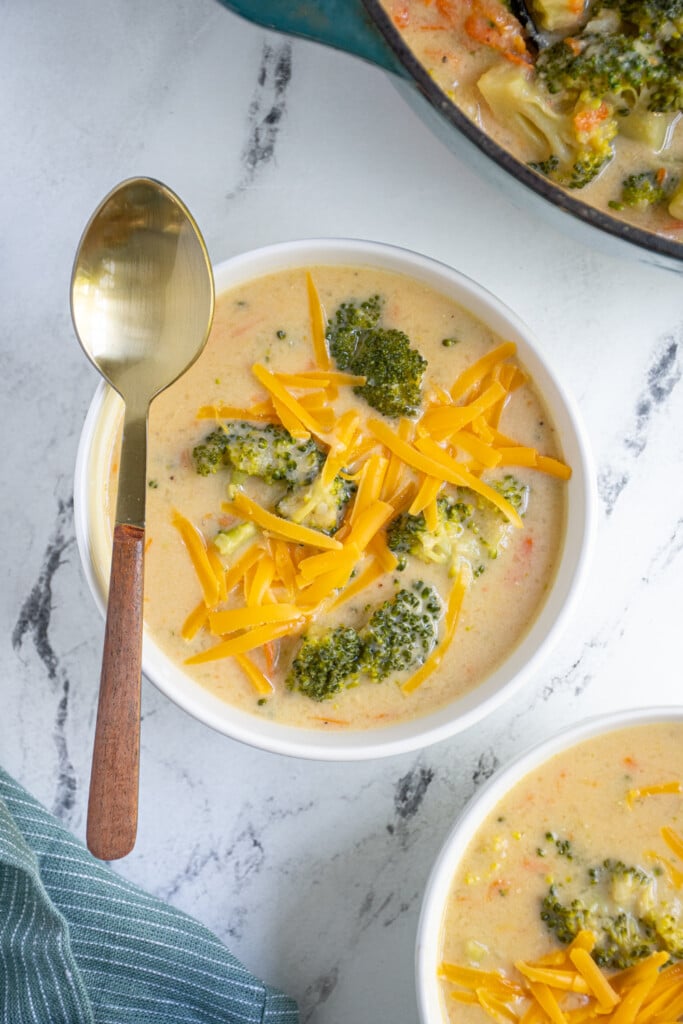 Overhead view of a bowl filled with Broccoli Cheddar Soup with a spoon ready to eat.