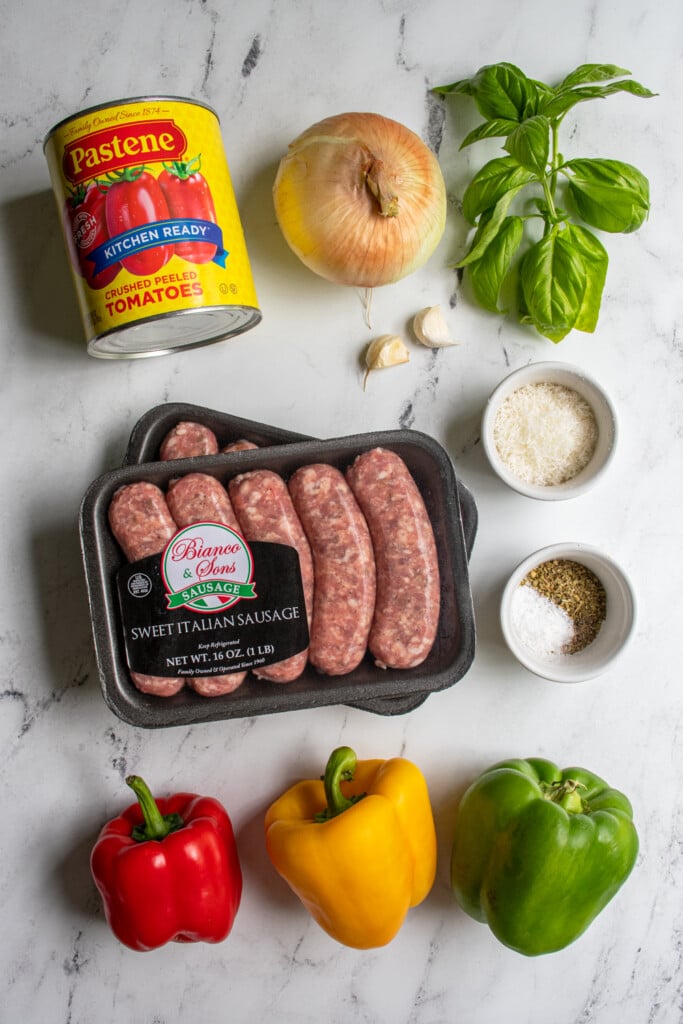 Ingredients for making crockpot sausage and peppers laid out on a tabletop.