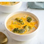 Pinterest pin with text overlay 'Healthy Broccoli Cheese Soup', image of white bowl filled with broccoli and cheese soup.