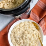 Pinterest Pin with text "Instant Pot Risotto", image of bowl of risotto and serving spoon.