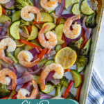 Pinterest pin with text 'Sheet Pan Shrimp & Veggies', image of a sheet pan with cooked pink shrimp and colorful vegetables.