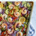 Pinterest pin with text 'Sheet Pan Shrimp & Veggies', image of a sheet pan with cooked pink shrimp and colorful vegetables.