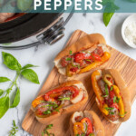 Pinterest Pin with text 'Crockpot Sausage & Peppers', image of Italian sausages in bun with peppers next to a crockpot.