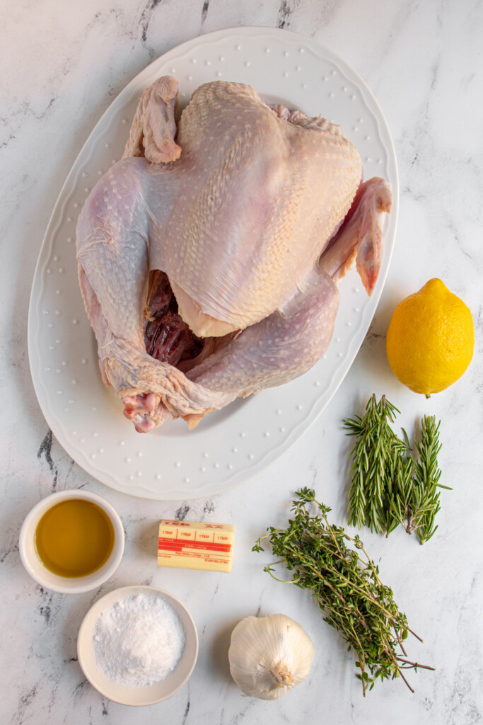 Ingredients needed to make an easy thanksgiving turkey laid out on a tabletop.