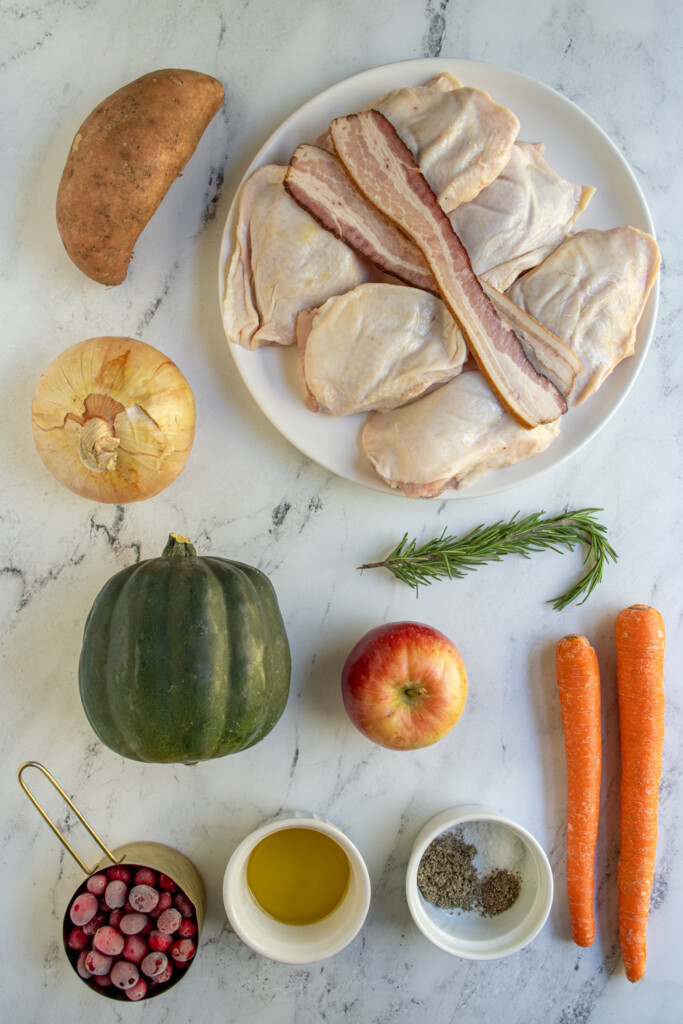All of the ingredients needed to make sheet pan fall harvest chicken dinner laid out on a tabletop.