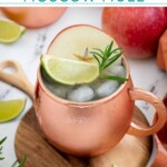 Pinterest pin with text overlay 'Apple Cider Moscow Mule', image of a copper mug full of apple cider mule garnished with apple, rosemary, and lime.