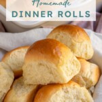 Pinterest pin with text over lay 'Homemade Dinner Rolls', image of a linen filled with a pile of soft homemade dinner rolls.