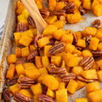Pinterest pin with logo overlay 'The Schmidty Wife', image os a sheet pan with cooked squash and pecans.