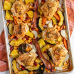 Pinterest pin with logo overlay 'The Schmidty Wife', image of a sheet pan with veggies and chicken thighs.