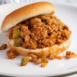 Pinterest pin with "The Schmidty Wife" Logo, image of sloppy joes in a bun on a plate.