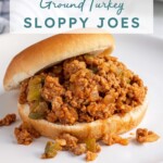 Pinterest Pin with text over lay 'Ground Turkey Sloppy Joes", image of a bun filled with sloppy joes on a plate.