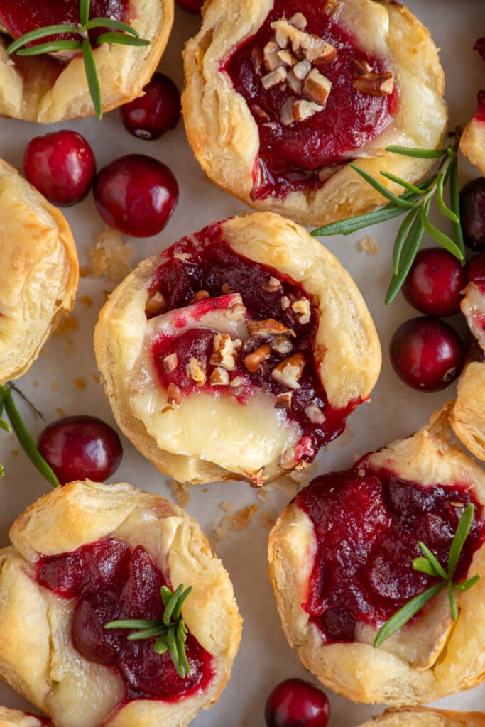 Close up of an overhead view of a cranberry brie bite garnished with finely diced nuts on a platter.