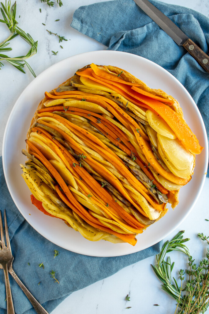 Close up of a root vegetable tarte tatin showing off rows of vegetables baked into an upside down pie.