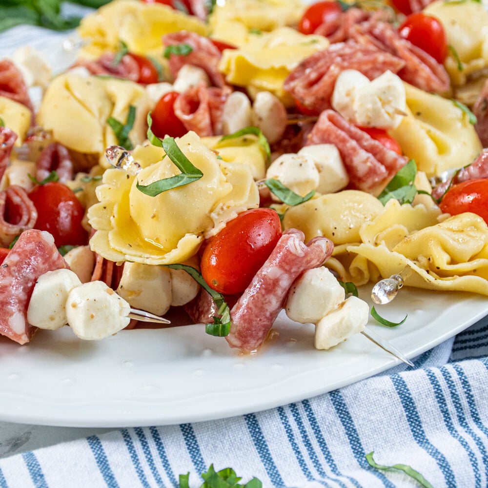 Close up of a single tortellini skewer on a platter full of this delicious and colorful appetizer.