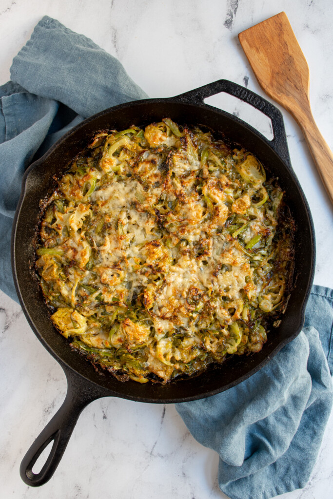 Overhead view of a cast iron skillet with cheesy brussel sprouts.
